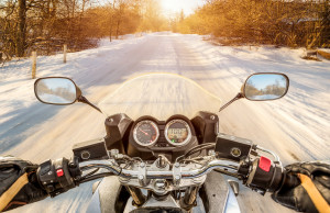 Biker rides on winter slippery road. First-person view.
